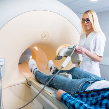 Médica preparando paciente para ressonância magnética do joelho