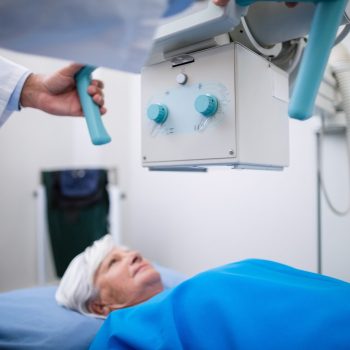 Senhora deitada realizando o procedimento de raio-x